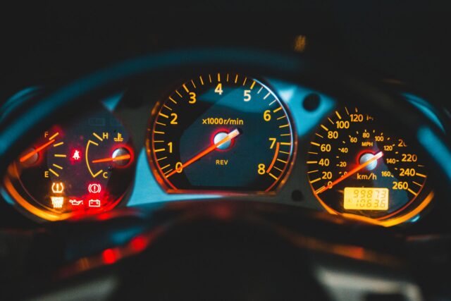 Bordul unei mașini sport, cu turometrul și vitezometrul iluminate, văzute de aproape
